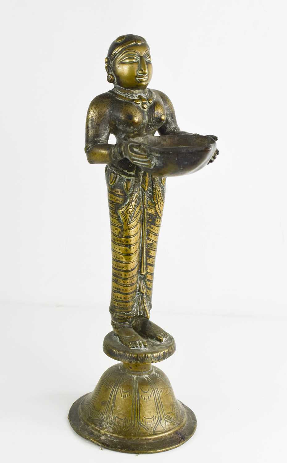 A 19th century Indonesian brass sculpture of a woman holding a bowl, raised on a bell form base, - Bild 2 aus 3