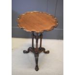 A 19th century mahogany pie crust occasional table with three column support and raised on three