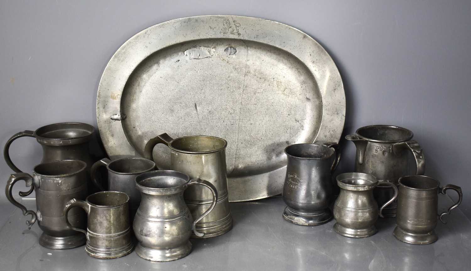 A collection of antique pewter, to include an oval platter, various tankards and jug.