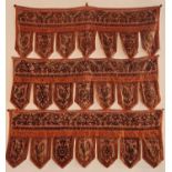 An antique medieval style tapestry wall panel, comprising three pelmets with red ground, 96cm by