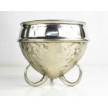 An Archibald Knox pewter bowl raised on three hoop feet, the body embossed with Art Nouveau style