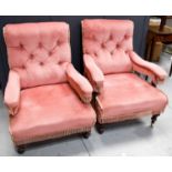 A pair of similarly sized Victorian armchairs, with out swept button backs, upholstered in pink with