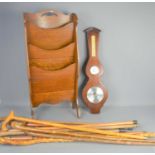 A 20th century barometer, a Mid-Century waterfall magazine rack and a group of walking sticks.