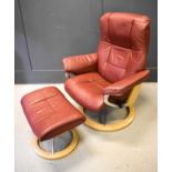 A dark red leather Norwegian Stressless reclining armchair and matching footrest
