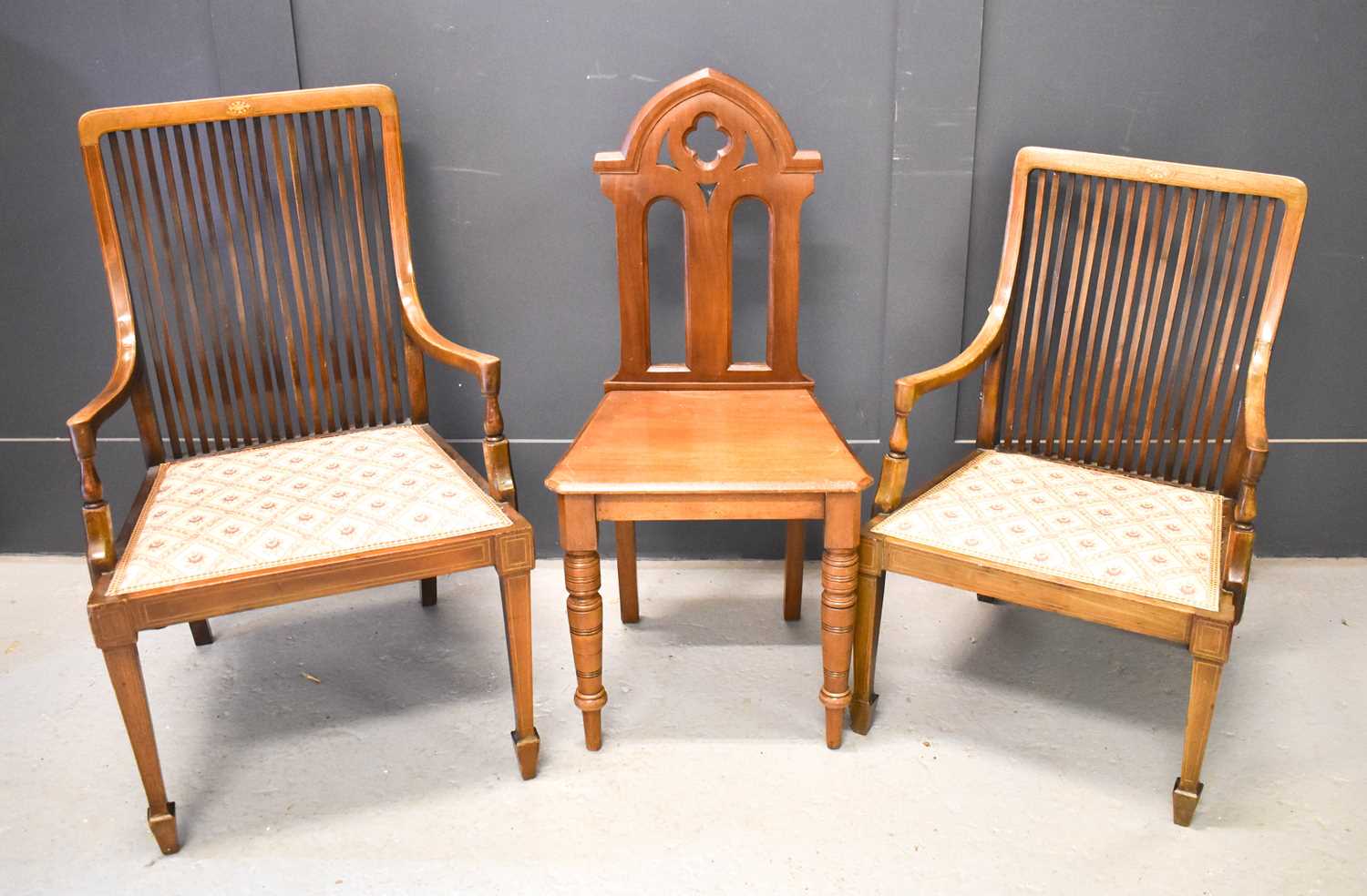 A 19th century mahogany hall chair with shaped back, together with two Edwardian comb backed