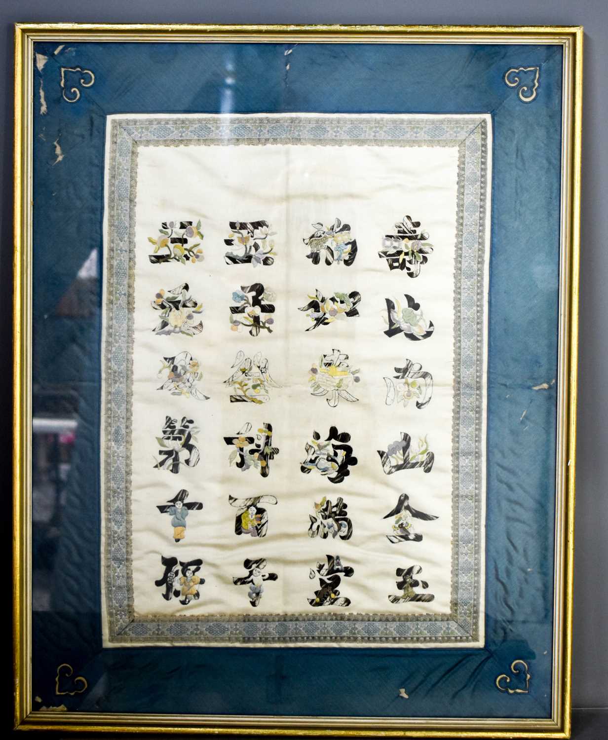 A late 19th century Chinese silk embroidered panel, depicting Chinese scrips within a blue silk