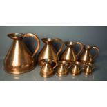A set of eight graduated Victorian copper measuring jugs.