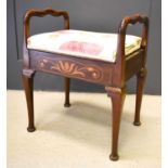 An Edwardian mahogany piano stool with floral inlaid sides and a hinged padded seat.