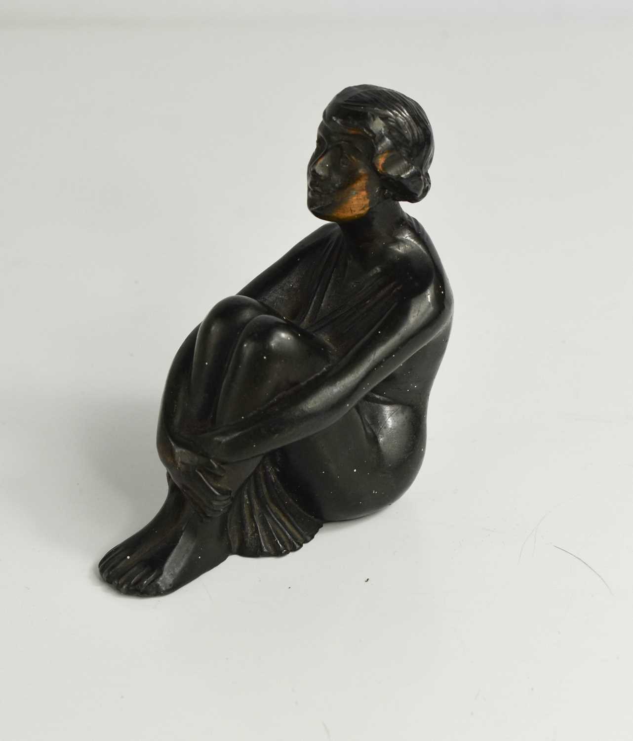 An Art Deco bronze car mascot in the form of a seated lady, 9½cm high.