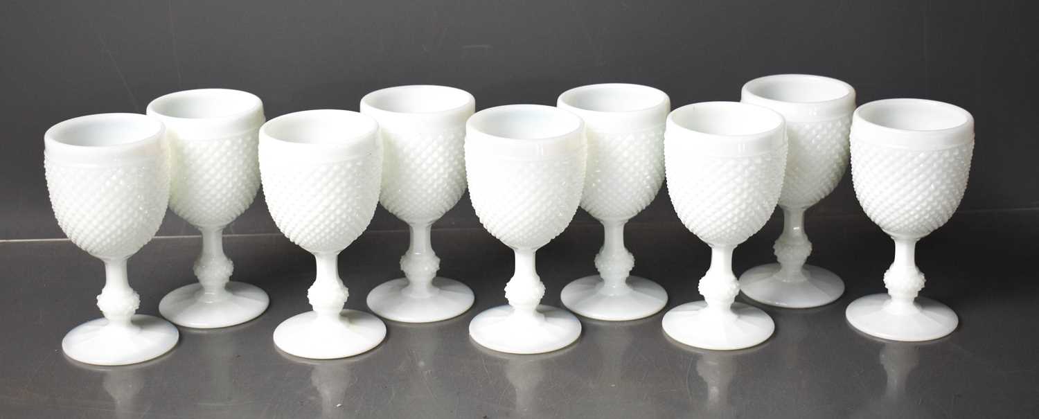 A set of nine white slag glass goblets.