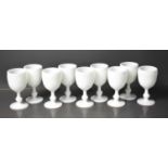 A set of nine white slag glass goblets.