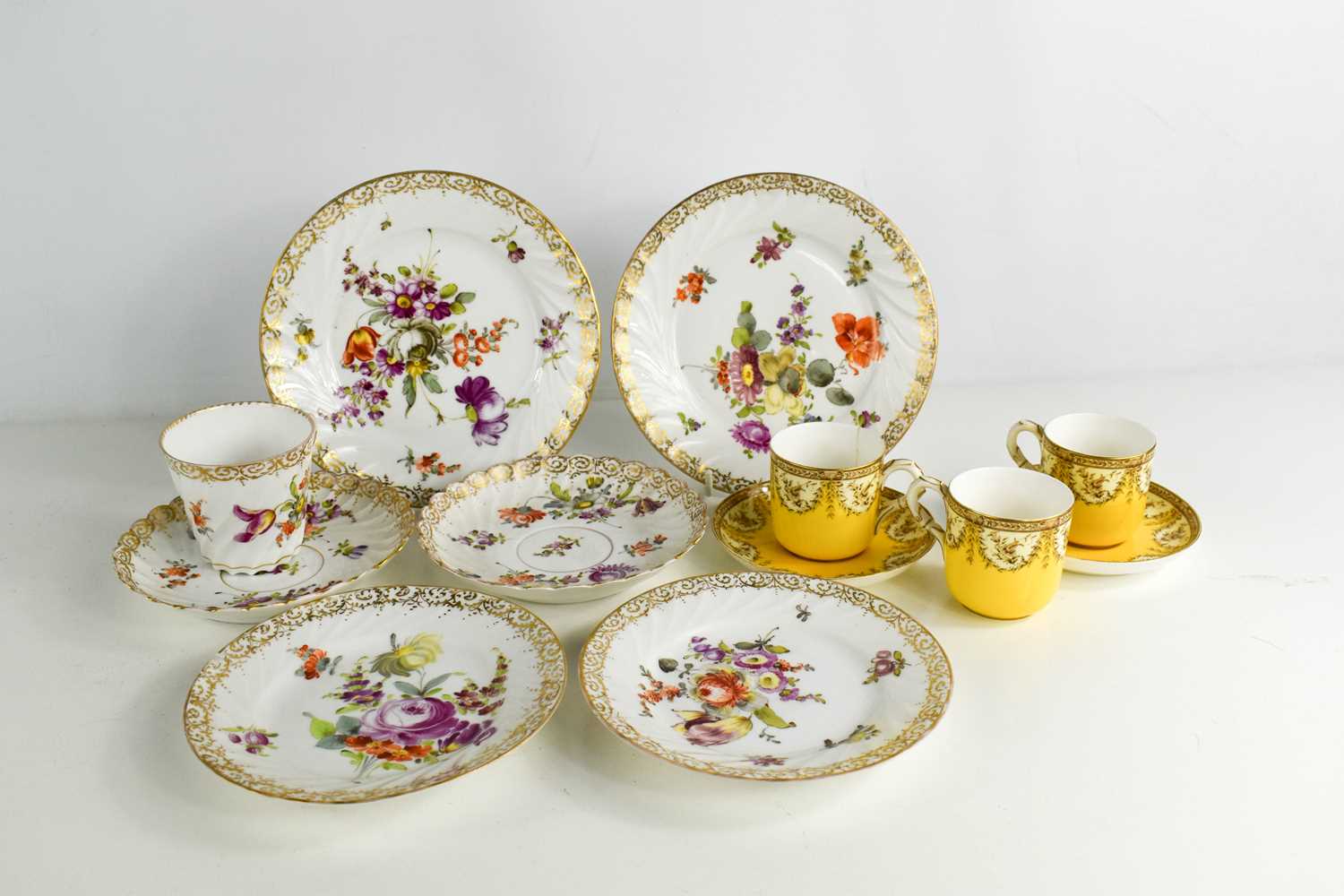 Two Royal Worcester coffee cans and saucers together with a group of Dresden porcelain plates