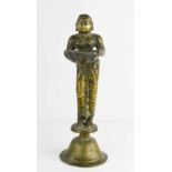 A 19th century Indonesian brass sculpture of a woman holding a bowl, raised on a bell form base,