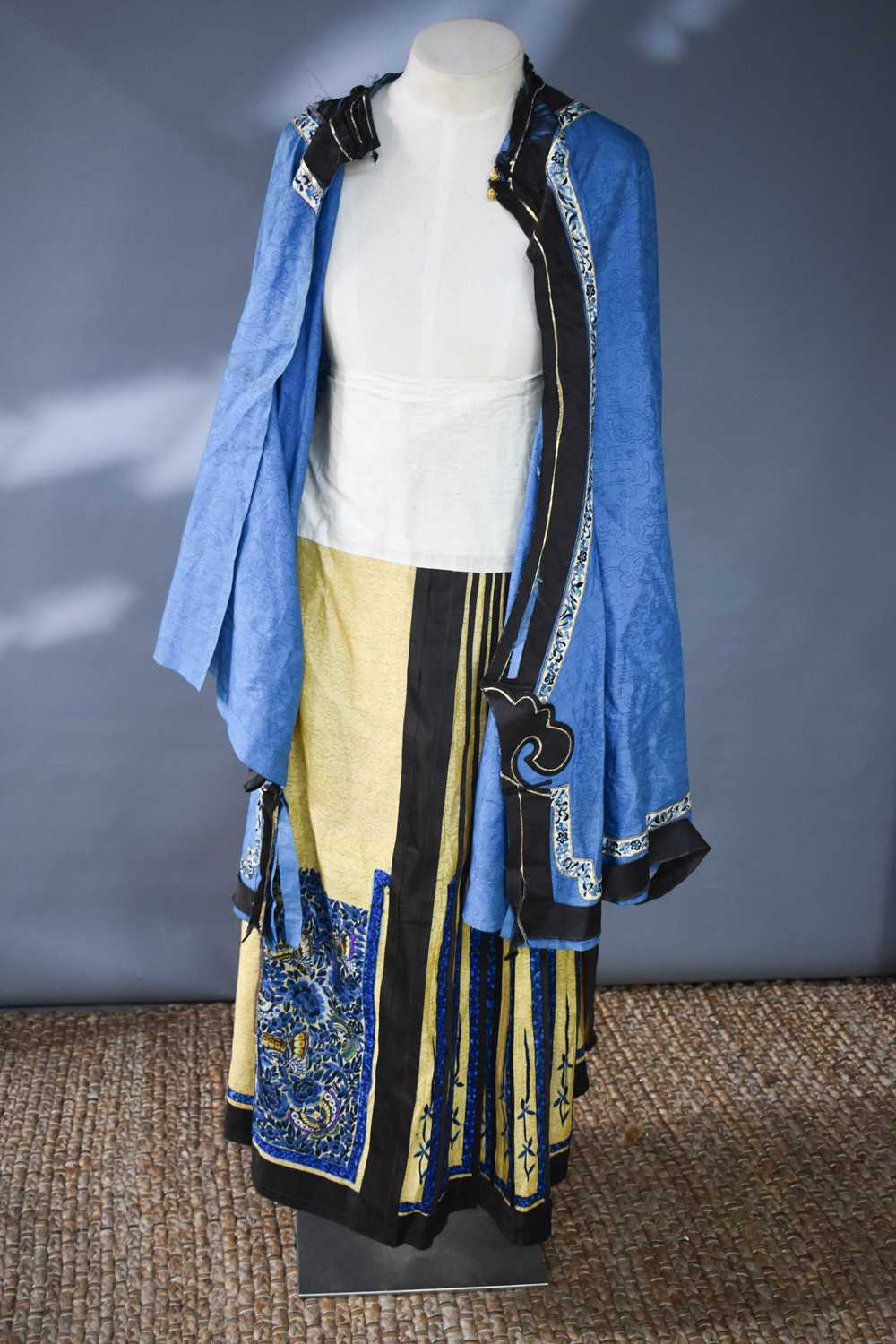 A late Qing dynasty embroidered skirt, the gold coloured cloud ground with blue embroidered panels