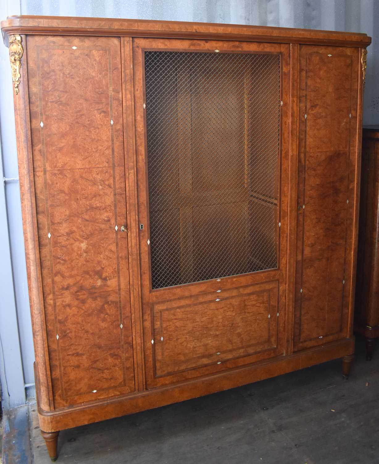 An early 20th century French burrwood cabinet, the central door having a grille panel opening to