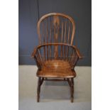 A 19th century elm Windsor armchair, the hoop back and bowed arm rail pierced with spindles and