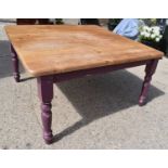 A modern pine dining table with baluster form legs, purple painted base, square top, made from