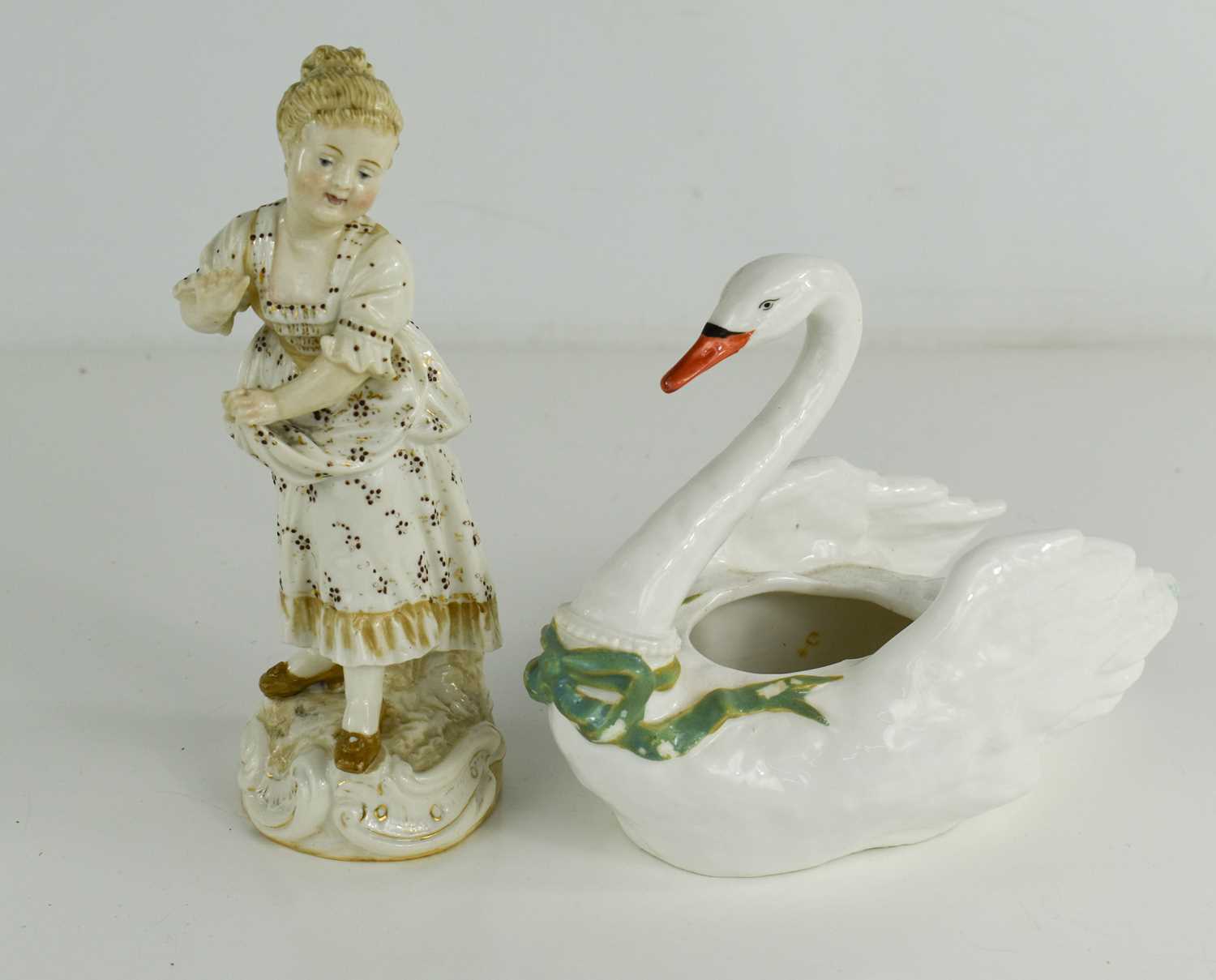 A porcelain swan salt, with green ribbon to the neck below beaded collar and hand painted face,