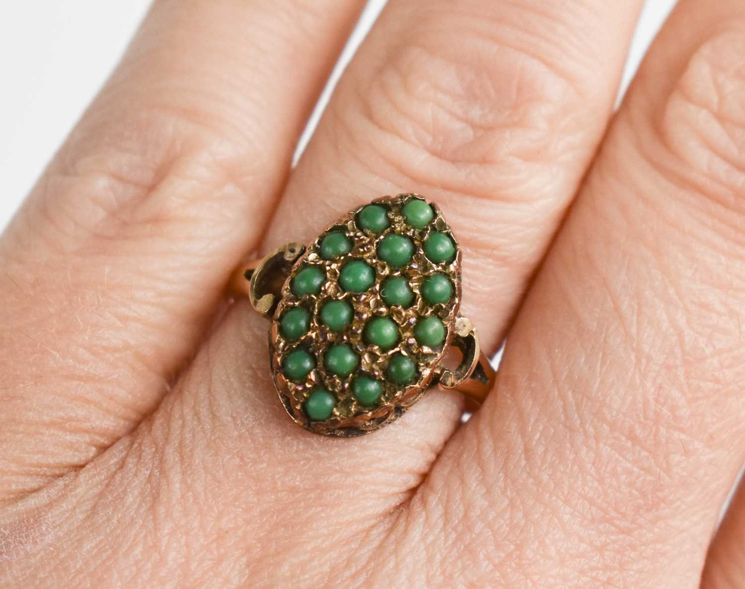 A vintage 9ct gold ring, the large marquise shaped setting with eighteen jade cabouchons, size O,