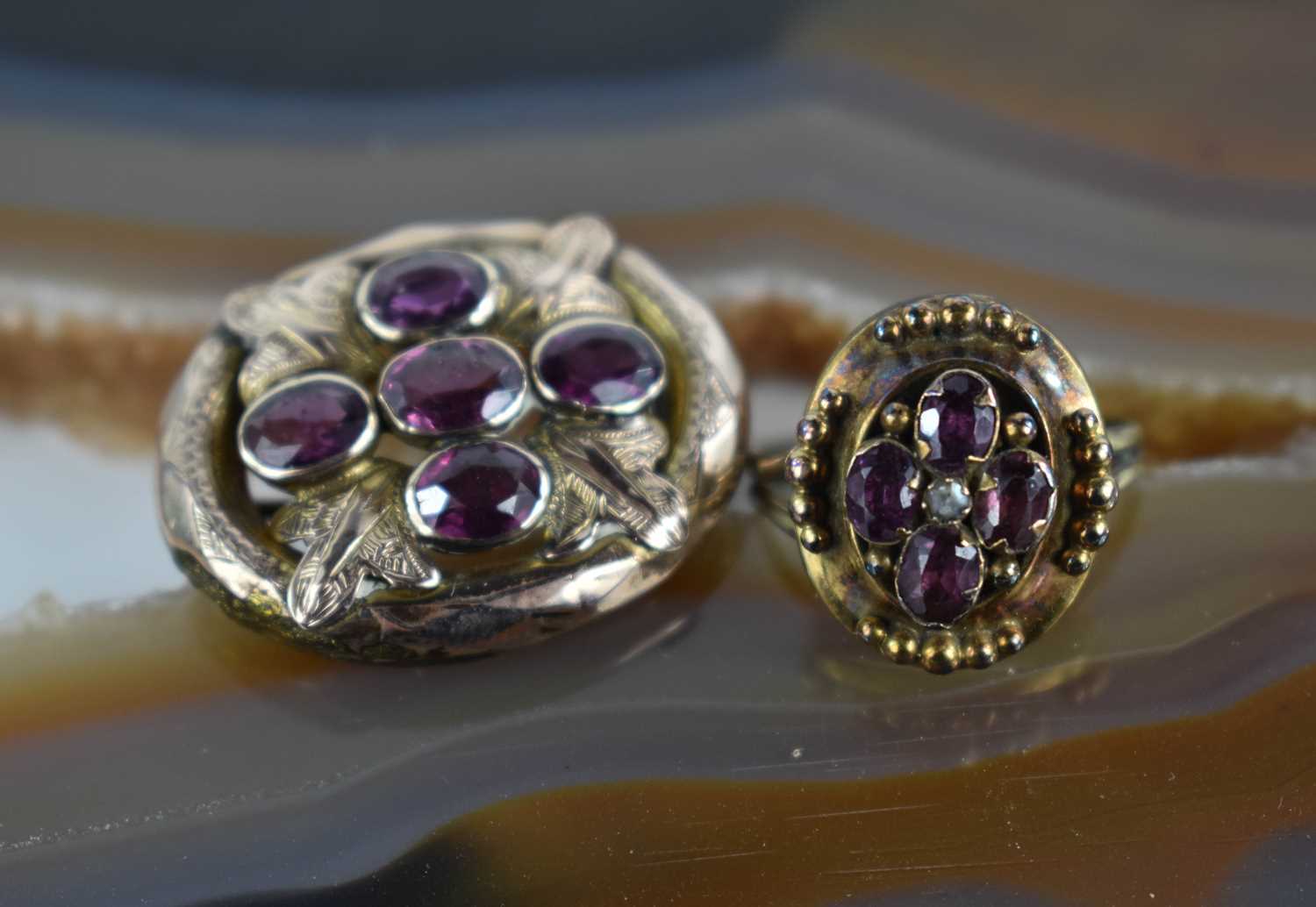 A 19th century rose gold coloured brooch set with five amethysts in a cruciform, with scrolled