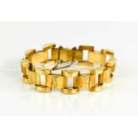 A 9ct gold, Modernist curved gate link bracelet, the stepped central panels with scroll engraving,