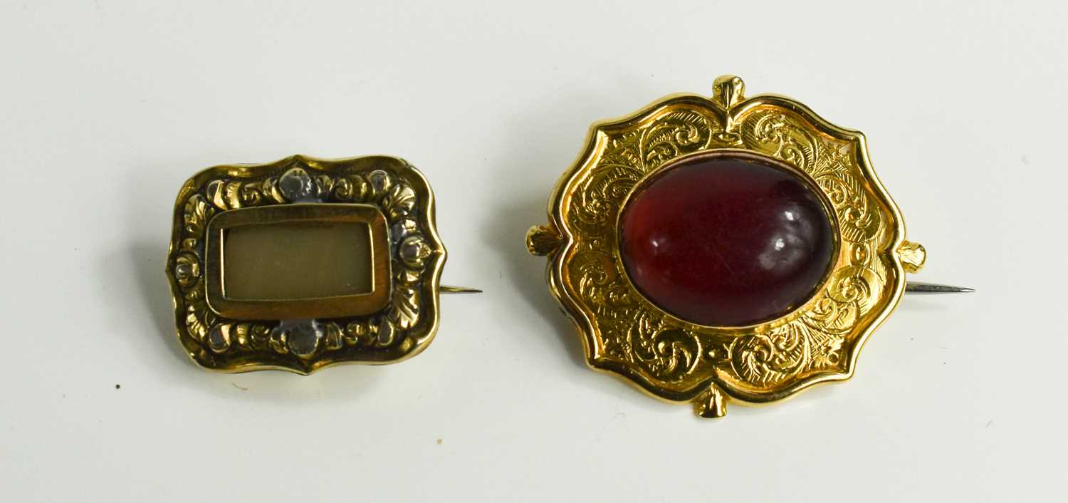 A quatrafoil brooch set with oval garnet cabouchon, with arched setting engraved foliate detail, - Bild 2 aus 3