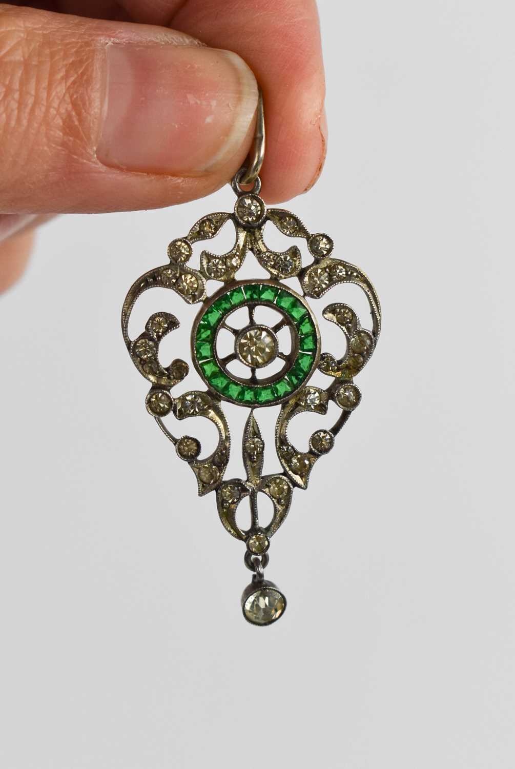 A stunning 19th century paste and silver pendant, set with a circle of green emerald cut paste