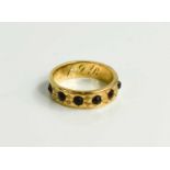 A 19th century wedding band set with garnets, foliate engraved with initials inside band, unmarked