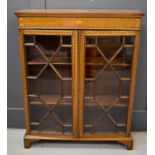 An Edwardian mahogany glazed display cabinet, inlaid with chevron banding and marquetry motifs, with