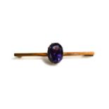 A rose gold (untested) and amethyst set brooch / tie pin, the oval amethyst in a claw setting on a