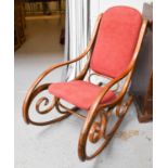 A vintage bentwood rocking chair with boldly scrolling sides.