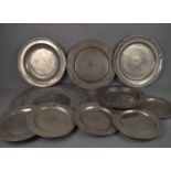 A group of ten antique pewter plates and chargers, some bearing owners initials, and another