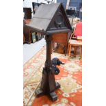 A gothic style oak lectern with twin book rests carved with gothic tracery raised on quatre form