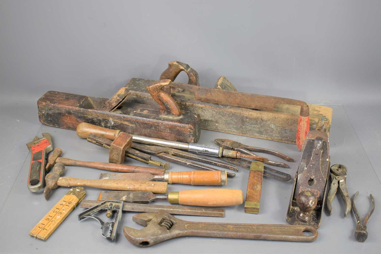 A group of vintage tools to include a Record plane, chisels, hammers, squares and others.