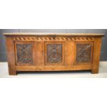 A 17th century oak coffer with candle box interior, chevron inlaid top rail and three carved panel