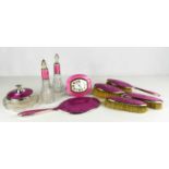 An Art Deco silver and pink enamelled dressing set, comprising alarm clock, pair of clothes brushes,