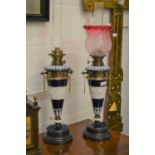 A pair of neo-classical Continental porcelain oil lamps of conical form, cobalt blue ground with