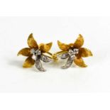 A pair of 18ct gold, white gold and diamond earrings in the form of flower heads, 5.9g.