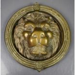 A brass lion head and hoop door knocker, 21cm diameter.