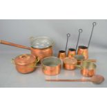 A group of three copper and wrought iron graduated cider measures together with copper saucerpans