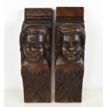 A pair of oak early 19th century carved corbels, depicting faces.
