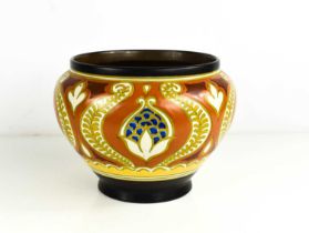 A Gouda Holland pottery bowl, with ochre and yellow ground, depicting stylized flowers, marked in