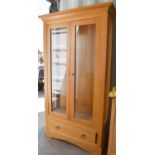 A modern beech display cabinet, with two glazed doors and drawer below, 190cm high by 106.5cm wide