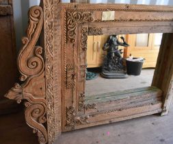 A large wooden window frame, made into a mirror, with a twin scroll pediment, 116cms tall by