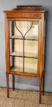 An Edwardian mahogany display cabinet with glazed single door and sides, decorated with boxwood