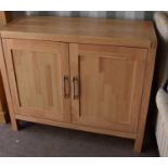 A beech cabinet with two panelled doors, 85cm high by 101cm wide by 41cm deep.