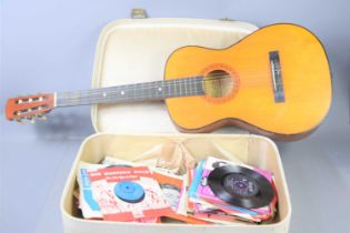 A group of 7" record singles, various artists together with a vintage acoustic guitar.
