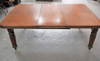 A Victorian mahogany wind out dining table with extra leaf, 69cm high by 180cm by 120cm.