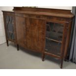 A mahogany sideboard, with two astragal glazed panel doors, flanking a bow front centre, raised on