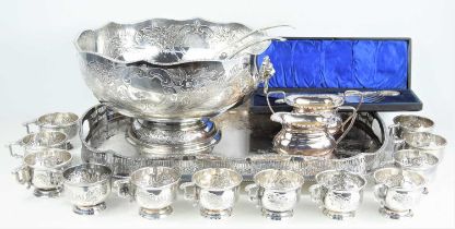 A large silver plated Victorian style punch bowl with embossed foliate decoration with matching